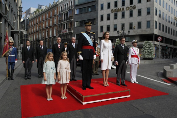 King Felipe VI, Queen Letizia, their daughters, Princess Leonor of Asturias, second left, and Princess Sofia, left,and Spanish Prime Minister Mariano Rajoy stand for the national anthem.