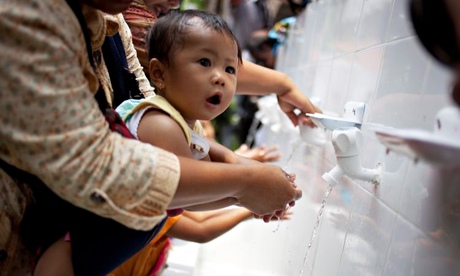 A mother help her baby to wash her hands in Jakarta, Indonesia