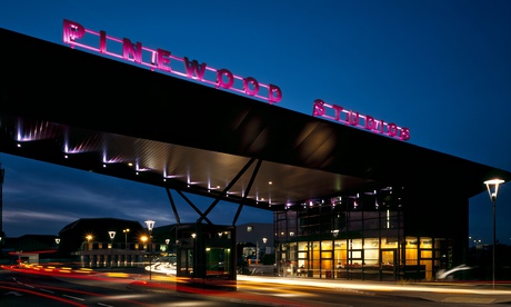 An impressive twilight view of Pinewood Studios, with letters lit in purple 