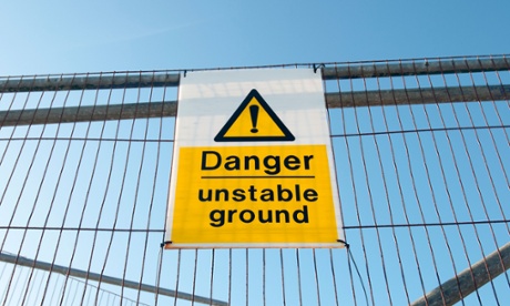 Danger unstable ground sign on a metal fence at fracking site.