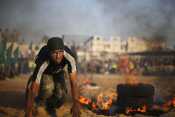 20 Photos: A Palestinian boy crawls next to burning tyres in Gaza