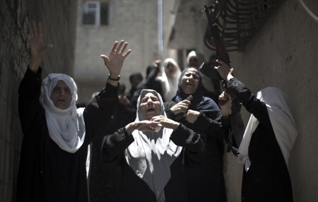 Relatives, including one wielding a gun, mourn a Palestinian man who died two days ago after an explosion caused the collapse of a tunnel under the Israeli border