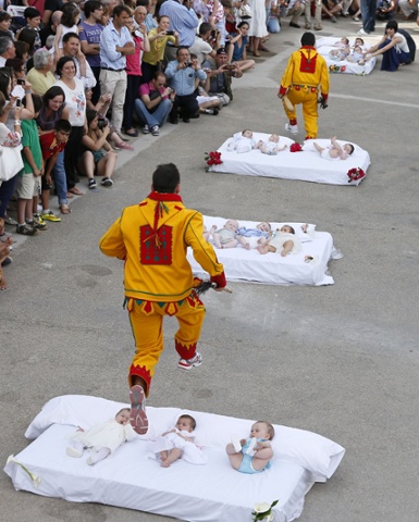 A man dressed up as the devil jumps over babies lying on a mattress in the street during El Colacho, the baby jumping festival in the village of Castrillo de Murcia. Photograph: Cesar Manso / AFP / Getty Images