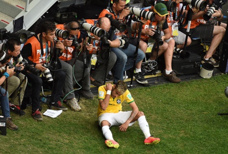 Brazil's forward Neymar is pushed into the bank of photographers by Nyom.