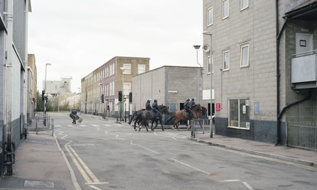 Officers on horses ride through the streets.