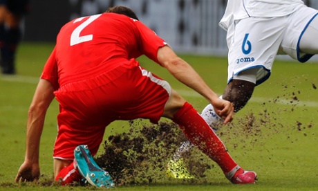 The field is dug up as Switzerland's Stephan Lichtsteiner fights for the ball with Juan Carlos Garcia of Honduras.