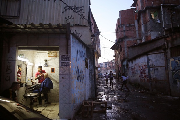 A barber's shop near the remains of demolished homes in the Metro Mangueira favela, near the Maracana stadium in Rio de Janeiro, Brazil. The homes were thought to have been knocked down for a car park for the stadium, though that has yet to be built.