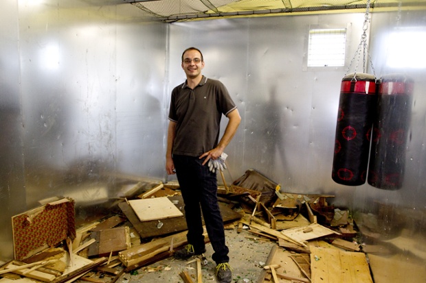 Alternative #2: Christian Castagnoli, creator of the 'rage chamber', stands in the room with broken furniture on the floor, in Forli, Italy. The rage chamber is a fully furnished room where people suffering from stress can vent their frustration.