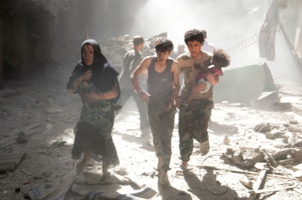 Aleppo residents, one of them carrying a wounded baby, flee the site of a reported barrel-bomb attack by Syrian government forces in the northern Syrian city.
