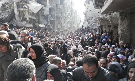 Residents wait to receive UN food aid at the al-Yarmouk camp