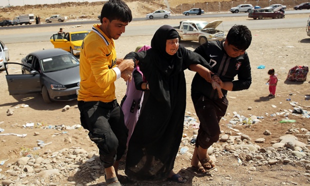 An elderly Iraqi woman is helped into a temporary displacement camp.