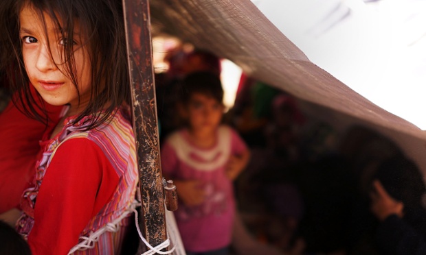 An Iraqi child waits with her family to get into the camp.