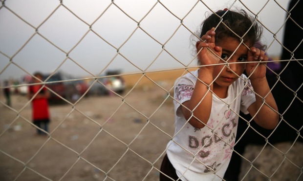 A child waits with her family.