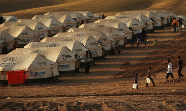 People walk between tents.