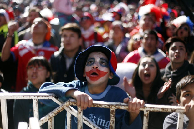 A young football fan watches the World Cup match between Brazil and Chile in Santiago de Chile. The Chilean national team lost on penalties.