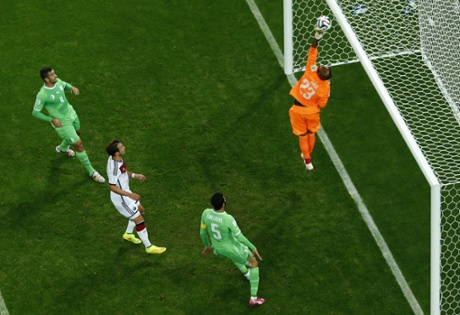 Algerian keeper Mbohli tips the ball over the bar.