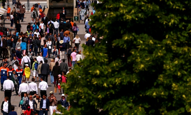 People walk along Allee Marcel Bernard backdropped by the monument to Suzanne Lenglen on day twelve of the French Open at Roland Garros.
