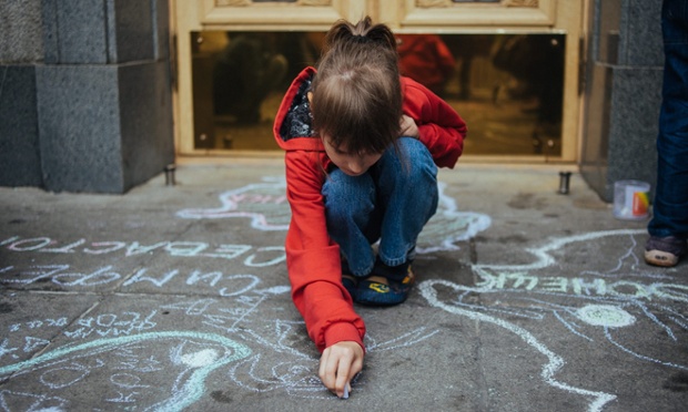 A child refugee draws symbolic maps showing her region and city, during a rally on the sidewalk at the entrance to the Ukrainian parliament during a protest in Kiev.