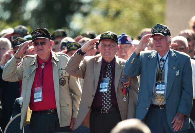 American veterans salute during a joint French-US D-Day commemoration ceremony at the Normandy American Cemetery and Memorial in Colleville-sur-mer, Normandy.