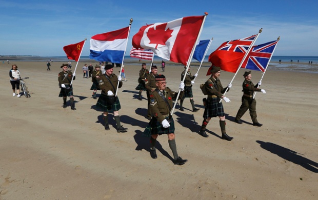 History enthusiasts from the Seaforth Highlanders of Holland march along the former Canadian D-Day landing zone of Juno Beach at Bernieres sur Mer.