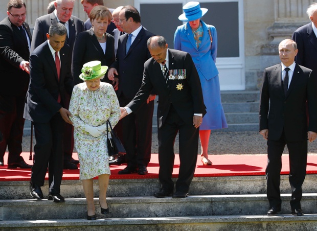 Russian President Vladimir Putin stands at right as U.S. President Barack Obama, left, and New Zealand's Governor-General Jerry Mateparae guide Britain's Queen Elizabeth II to her position for a group photo in Benouville.