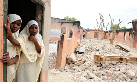 Schoolgirls stand in a Maiduguri classroom burnt by Boko Haram in May