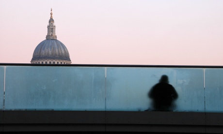 A homeless man sitting on Millenium Bridge, St Paul's Cathedral in the background 