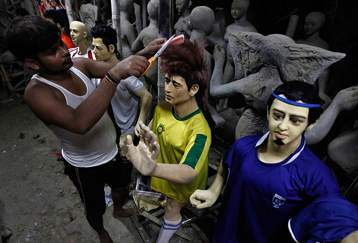 world cup fever: An artisan cuts the hair of a clay model 