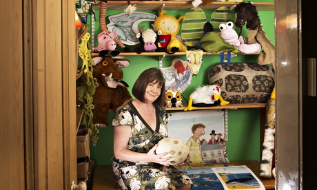 Julia Donaldson sitting in a small room among shelves of toys and props