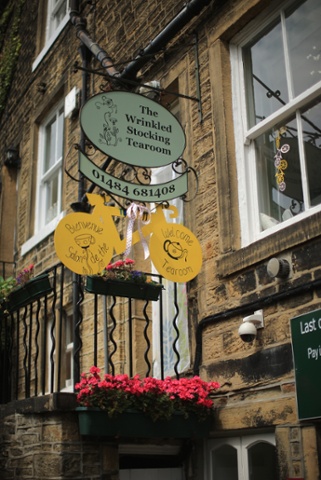 A yellow bicycle hangs from the Wrinkled Stocking Tearoom in Holmfirth