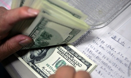 An employee counts U.S. dollars at a money exchange in Tokyo