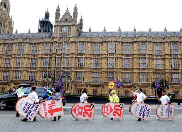 Public sector workers and members of Unison gather outside the Houses of Parliament in central London as they take part in the one-day walkout as part of bitter disputes over pay, pensions, jobs and spending cuts.