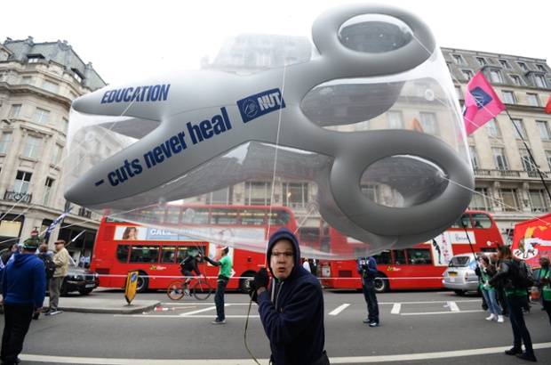 A public sector worker carrying a balloon in the shape of scissors marches during a demonstration against austerity cuts in London. According to media reports, thousands of workers participated in the strike.