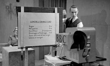 17th April 1948:  A BBC studio team member holds up a recipe board for 'orange or lemon curd' to the camera.