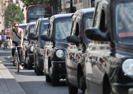London cabs, fitted with diesel engines, line up along Oxford Street in London.