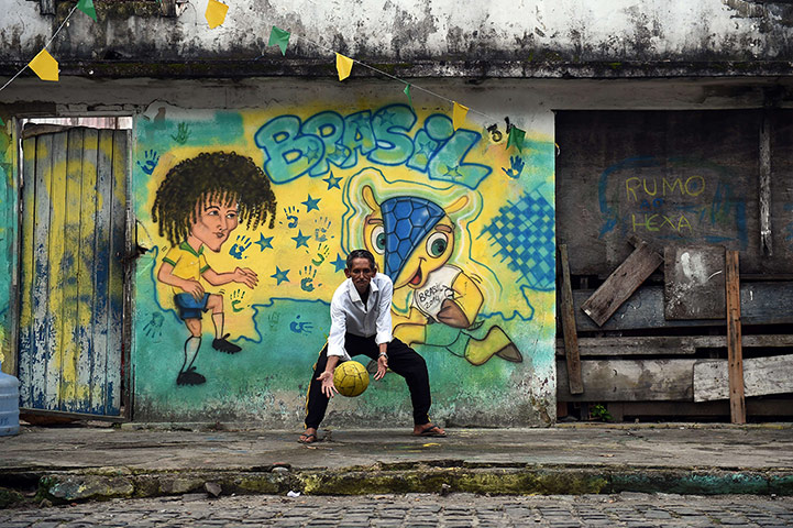 World Cup fans: TOPSHOTS  A Brazilian man plays football
