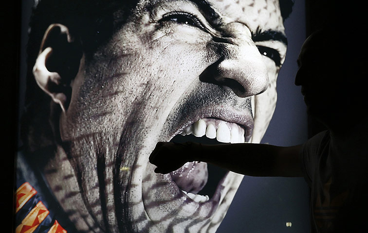 20 Photos: An advertising placard showing Uruguay's Suarez flashing teeth in Rio