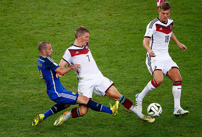 Schweinsteigar's Final: Javier Mascherano and Bastien Schweinsteiger stretch for the ball 