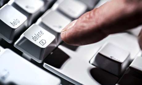 A finger pressing delete on a computer keyboard