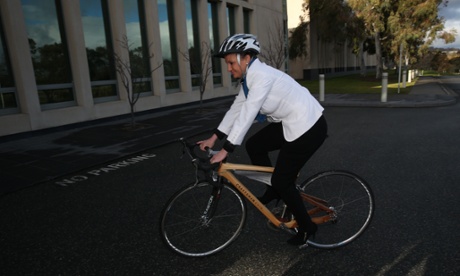 PUP senator Jacqui Lambie rides a bike made of wood belonging to the Australian Forest Products Association known as 