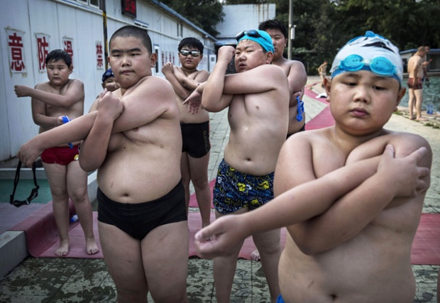 Children stretch after swim training at a camp held for overweight children in Beijing, China