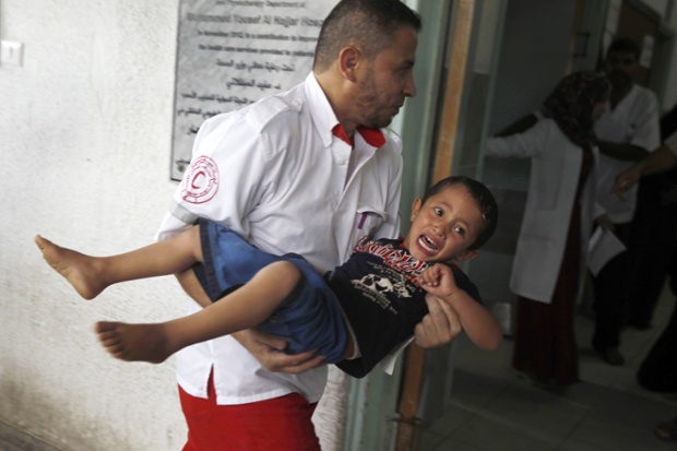 An injured child is carried into an hospital in Rafah, Gaza Strip, following an Israeli air strike