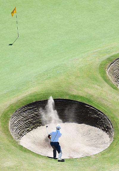 open golf day 1: Tiger Woods chips from a bunker 
