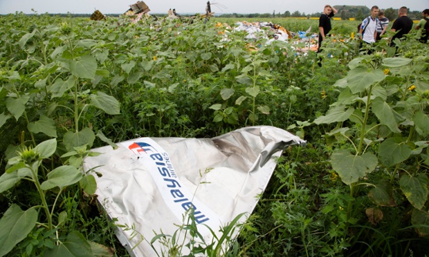 A piece of flight MH17 lies in the grass as a group of Ukrainian coal miners search the site near the village of Rozsypne, Ukraine, where the Malaysian plane came down killing all 298 aboard.