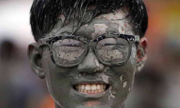 A tourist poses for photographs as he plays in the mud during the Boryeong Mud Festival at Daecheon South Korea.