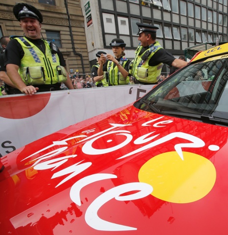 British police officers stand next to the car of Tour de France director Christian Prudhomme prior to the start of the first stage of the Tour de France cycling race over 190.5 kilometers (118.4 miles) with start in Leeds and finish in Harrogate, Britain.
