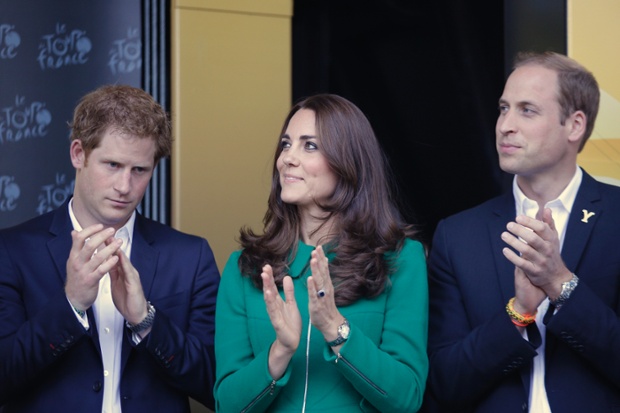 Britain's Prince Harry, left, Prince William, right, and Kate, Duchess of Cambridge, watch stage winner Marcel Kittel of Germany on the podium of the first stage of the Tour de France cycling race over 190.5 kilometers (118.4 miles) with start in Leeds and finish in Harrogate, England.