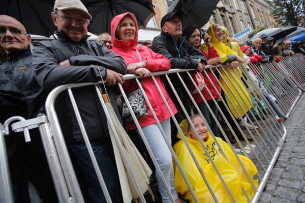 Spectators take cover from the rain as they watch the start of the fifth stage of the Tour de France cycling race over 155 kilometers (96.3 miles) with start in Ypres, Belgium, and finish in Arenberg, France.