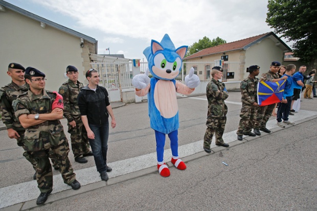French soldiers and a person in disguise wait for the the pack to pass during the eighth stage of the Tour de France cycling race over 161 kilometers (100 miles) with start in Tomblaine and finish in Gerardmer, France.