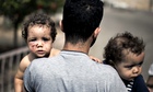 A Palestinian holds his daughters, Shada and Lama al-Ejla, injured in an Israeli tank attack